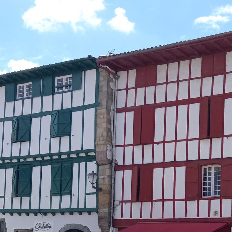 Alignement de maisons traditionnelles basques à colombage vert et jaune